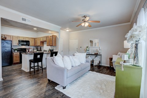 a living room and kitchen with a couch and a ceiling fan